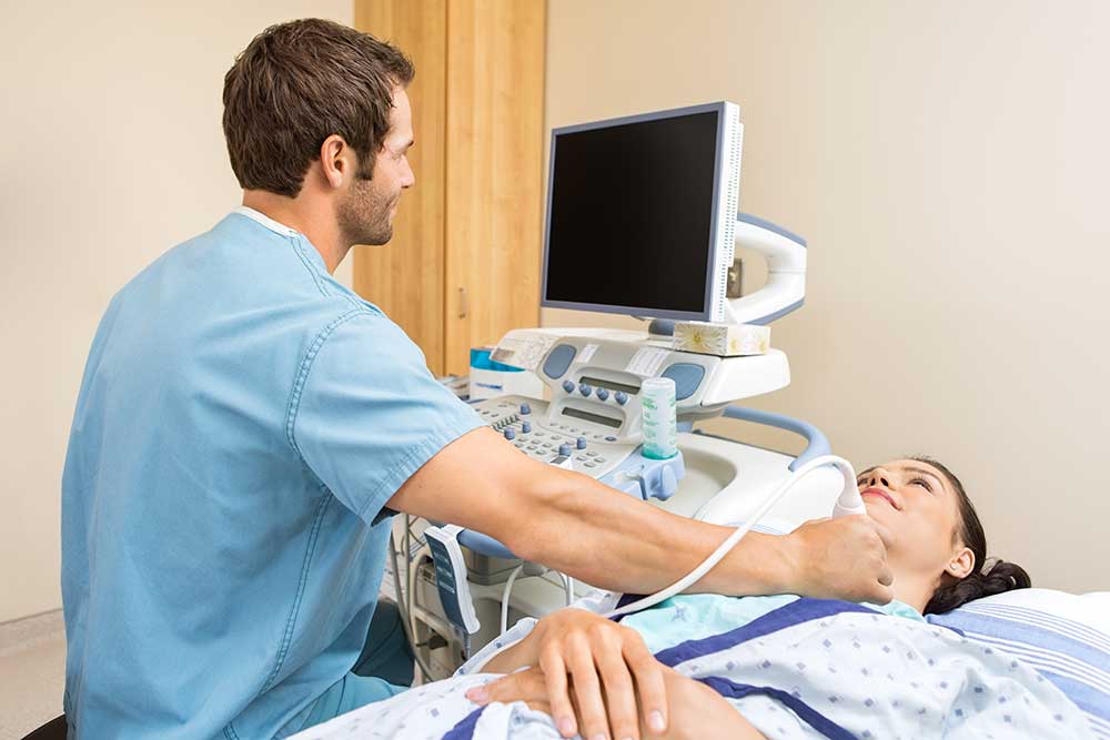 sonographer performing an ultrasound on a woman